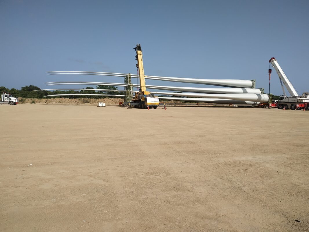 Grúas móviles manipulando aspas de aerogenerador en el patio de la zona franca