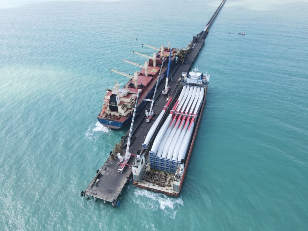 Descarga de aspas de aerogenerador desde una barcaza en el muelle de Puerto Brisa